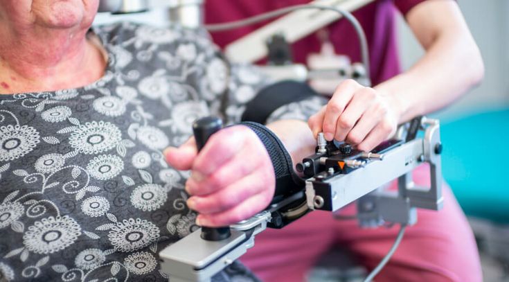 Patientin trainiert ihren Arm in der Armtherapie