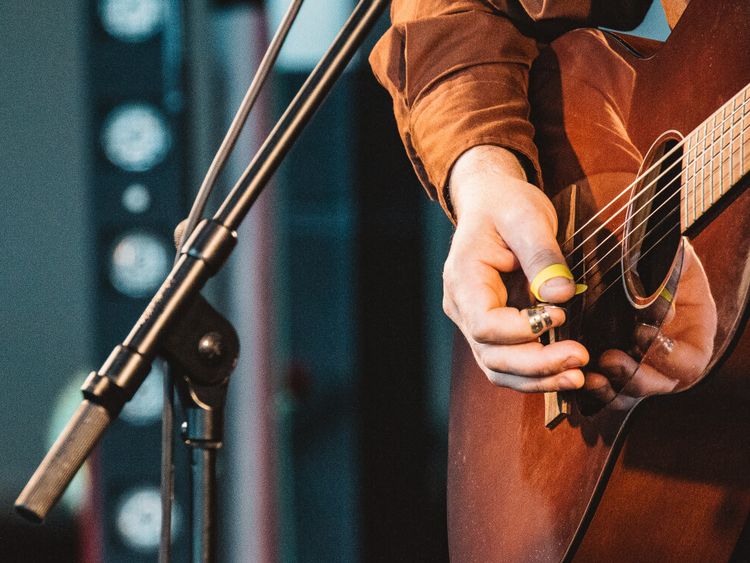 Ein Mann spielt auf einer Bühne Gitarre