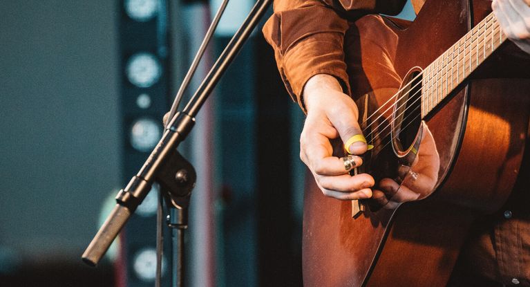 Ein Mann spielt auf einer Bühne Gitarre