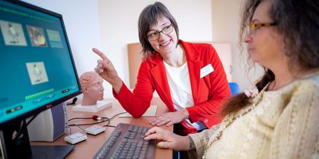 Psychotherapie Therapeutin und Patientin beim Gehirnleistungstraining am Bildschirm