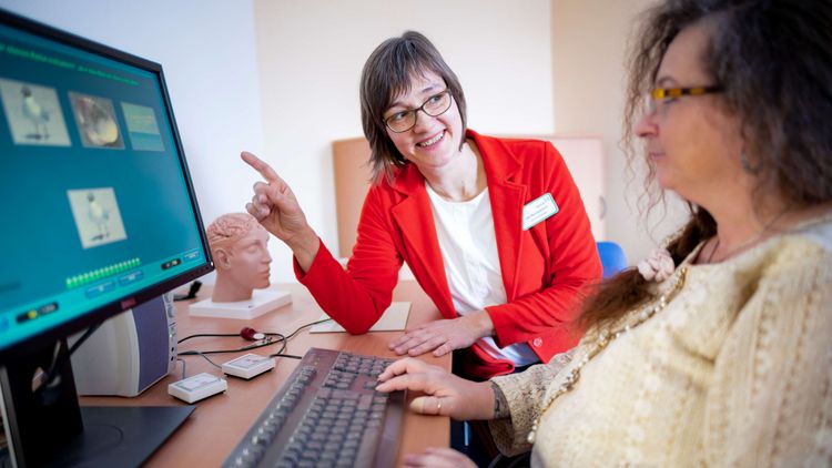 Therapeutin und Patientin beim Gehirnleistungstraining am Bildschirm