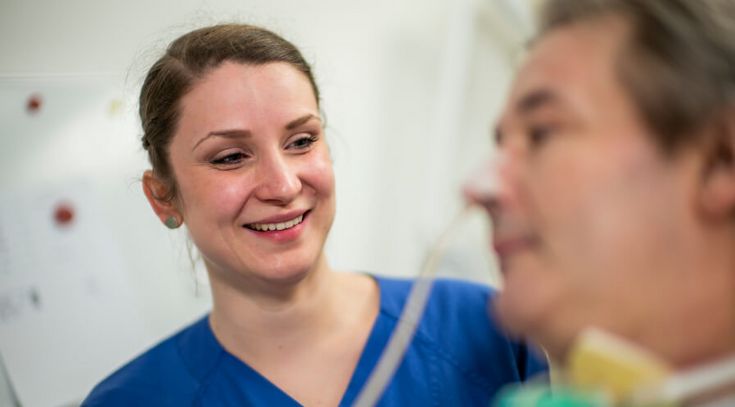 Pflegekraft mit Neurologie-Patienten am Krankenbett