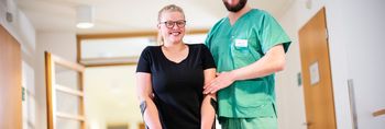 Amputierte Patientin mit Pfleger beim Gangtraining