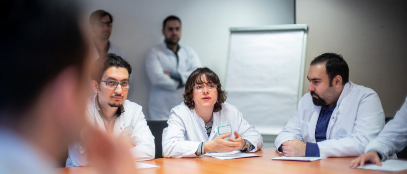 Ärzte besprechen Patientenfälle in einer Konferenz