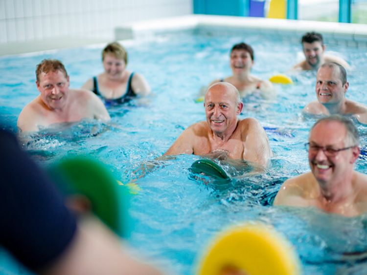 Eine Gruppe von Patienten trainiert gemeinsam im Schwimmbad