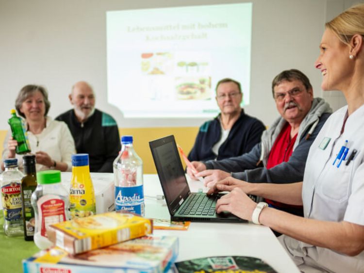 Eine Ernährungsberaterin klärt eine Patientengruppe über Lebensmittel auf