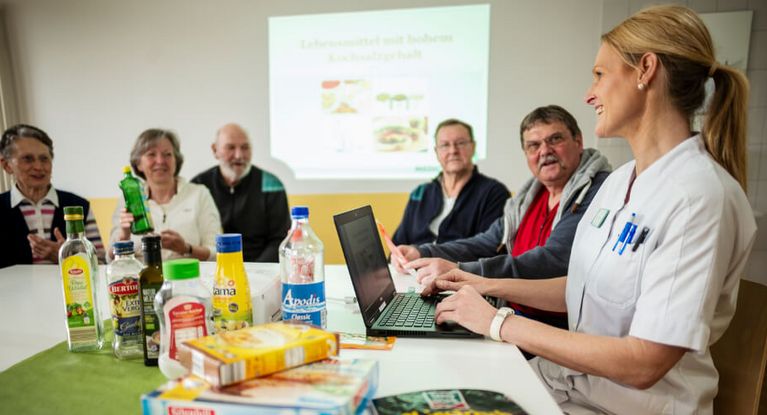 Eine Ernährungsberaterin klärt eine Patientengruppe über Lebensmittel auf