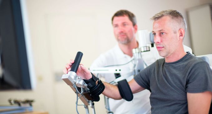 Therapeut unterstützt Patienten bei der Motoriktherapie