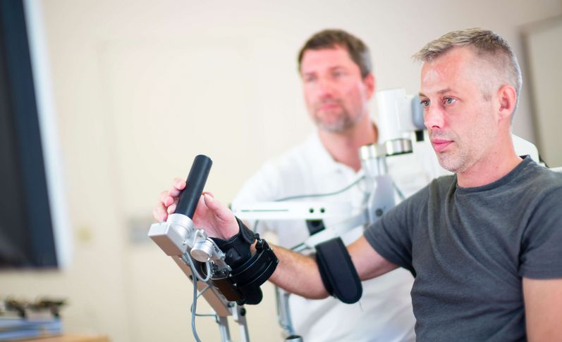 Therapeut unterstützt Patienten bei der Motoriktherapie