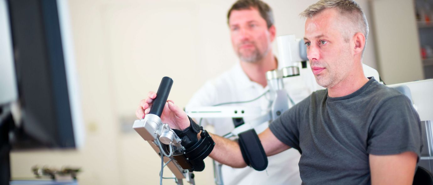 Therapeut unterstützt Patienten bei der Motoriktherapie