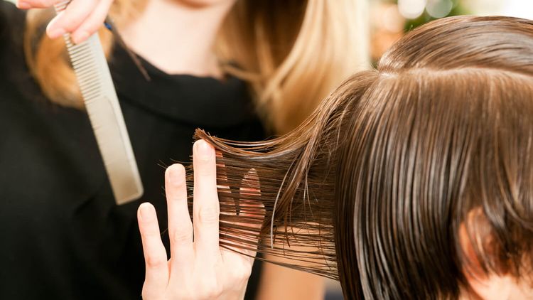 Friseuse ordnet Frisur einer Kundin