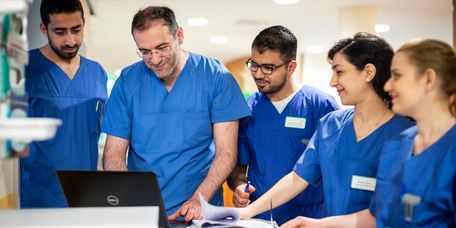 Fallbesprechung Neurologie Ein Team aus Ärzten und Pflegekräften besprechen Patientenakten