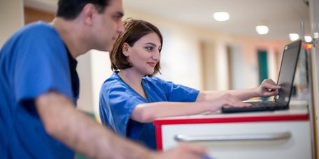 Ärzte im Gespräch Pflegekräfte besprechen eine Pateintenakte