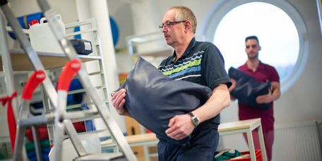 Patient trägt einen Sack in der medizinisch-beruflich orientieren Rehabilitation