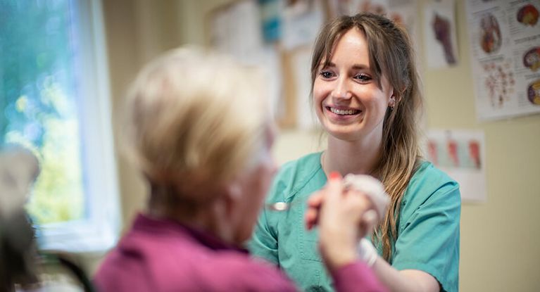 Schlucktherapie Therapeutin unterstütztPatienten bei der Schlucktherapie