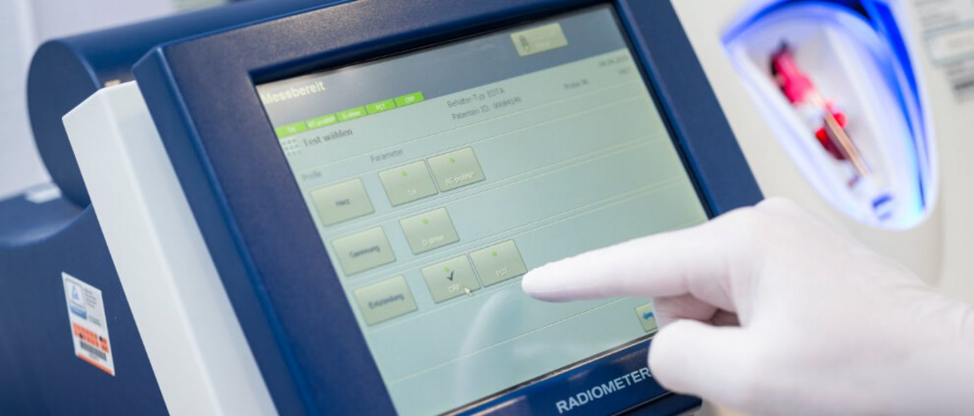 Eine behandschuhte Hand bedient den Bildschirm eines Radiometers