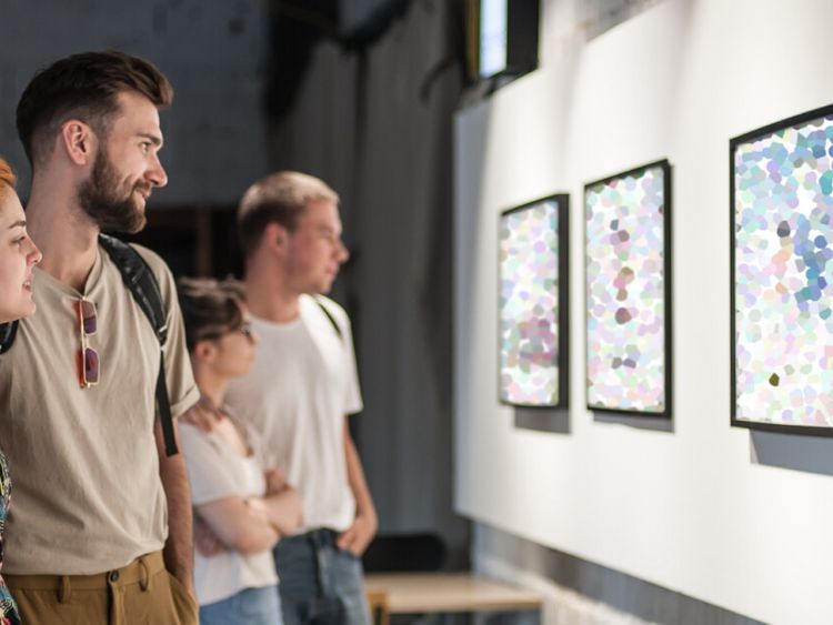 ein Gruppe schaut sich Gemälde imMuseum an