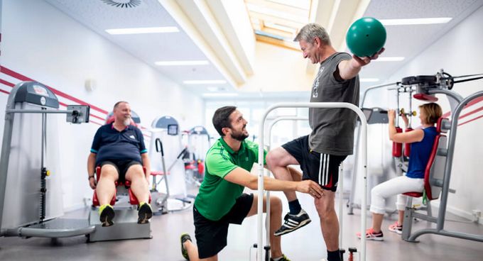 Therapeuten unterstützen Patienten bei der Therapie im MTT-Raum